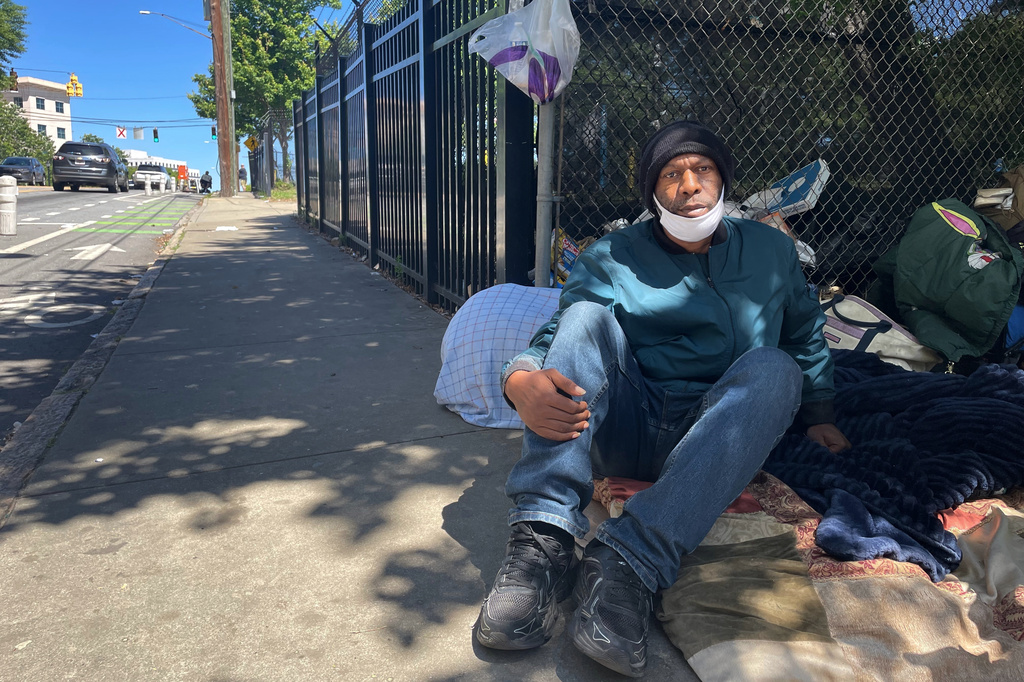 Tommy Elam sits on a sidewalk with his belongings in downtown Atlanta on Thursday, May 14, 2026. (AP Photo/R.J. Rico)