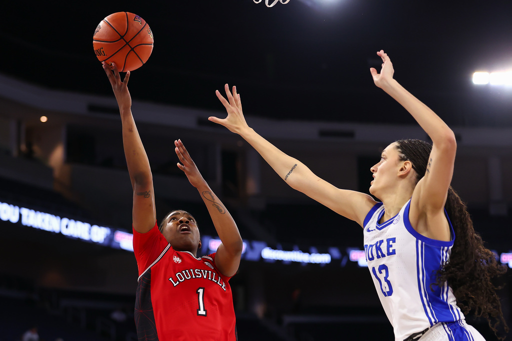 Louisville guard Reyna Scott (1) shoots against Duke forward Jordan Wood (13) during the first half of an NCAA college basketball game in the championship of the Atlantic Coast Conference tournament, Sunday, March 8, 2026, in Duluth, Ga. (AP Photo/Colin Hubbard)