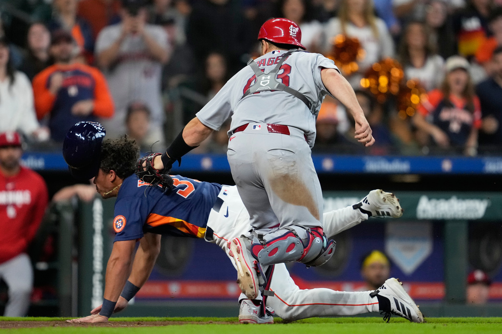 St. Louis Cardinals catcher Pedro Pagés (43) tags out Houston Astros' Dustin Harris during the tenth inning of a baseball game in Houston, Sunday, April 19, 2026. (AP Photo/Ashley Landis)