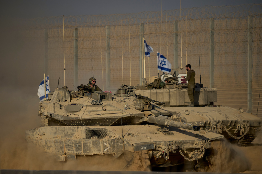 Israeli tanks move along the Israeli-Gaza border as seen from southern Israel, Monday, Oct. 20, 2025. (AP Photo/Ohad Zwigenberg)