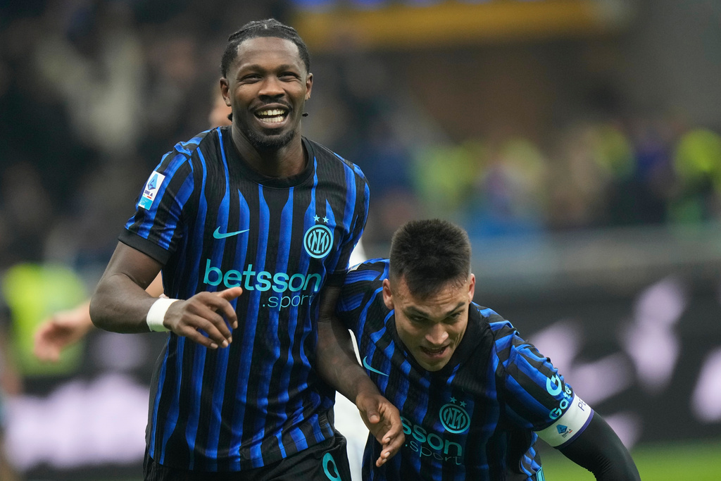 Inter Milan's Marcus Thuram, left, celebrates with his teammate Lautaro Martinez after scoring his side's second goal during a Serie A soccer match between Inter and Como, in Milan, Italy, Saturday, Dec. 6, 2025. (AP Photo/Luca Bruno)