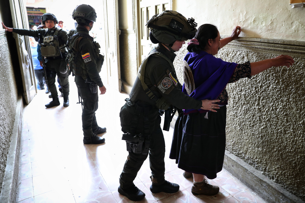 Police frisk voters arriving to a polling station during presidential election in Silvia, Colombia, Sunday, May 31, 2026. (AP Photo/Santiago Saldarriaga)