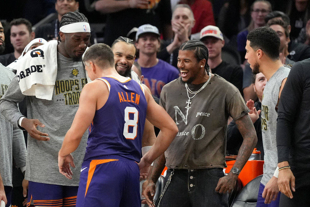 Phoenix Suns guard Grayson Allen (8) celebrates his 10th 3-pointer against the New Orleans Pelicans with teammates, including Suns' Jalen Green, second from right, Devin Booker, right, and Mark Williams (15), left, during the second half of an NBA basketball game Monday, Nov. 10, 2025, in Phoenix. (AP Photo/Ross D. Franklin)