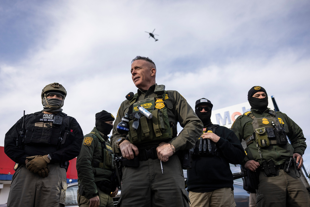 U.S. Border Patrol Cmdr. Gregory Bovino, center, looks on after federal immigration enforcement agents detained an individual outside a Mobil gas station in Evanston, Ill., Wednesday, Dec. 17, 2025. (Ashlee Rezin/Chicago Sun-Times via AP)