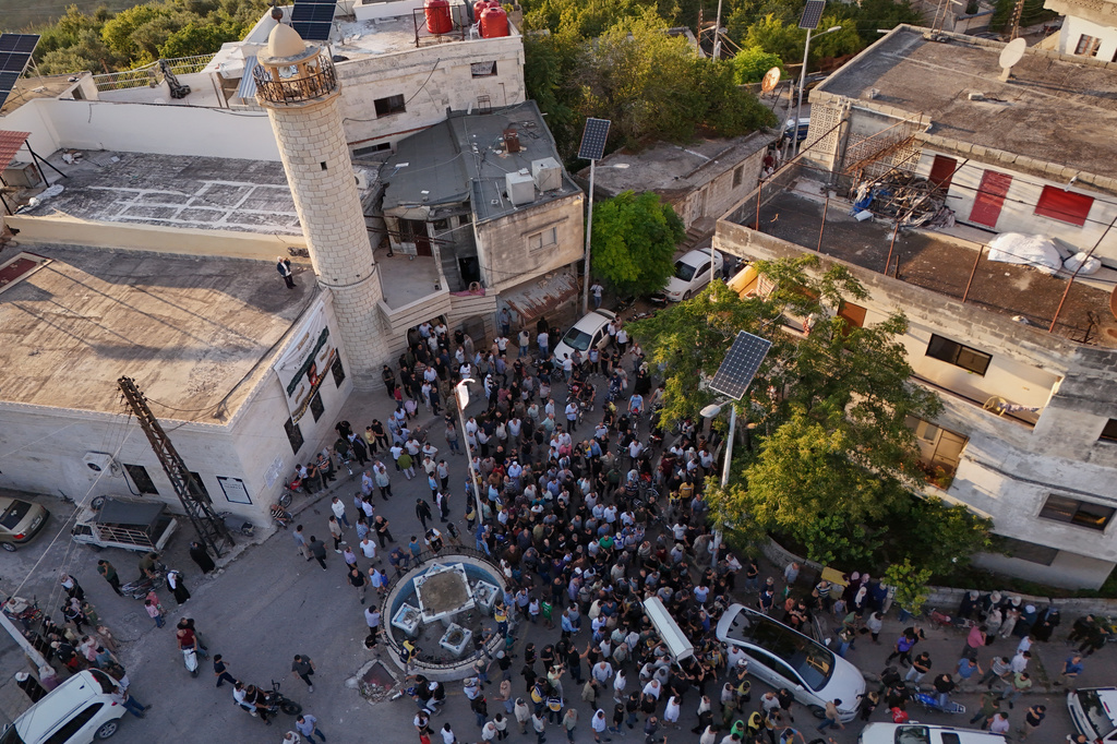 Mourners carry the coffin of Mohammad Ghamira, a former White Helmets volunteer who died shortly after his release from jail, for burial in the village of al-Haffa, in Latakia province, Syria, Monday, Aug. 17, 2026. (AP Photo)