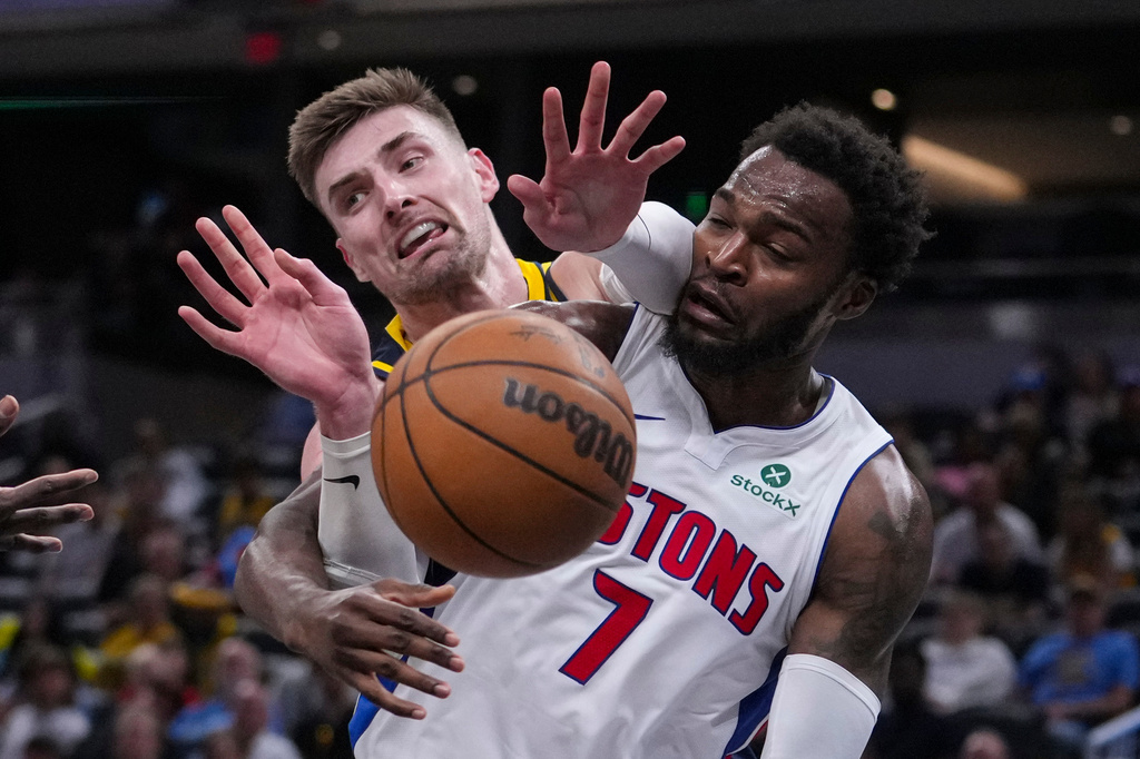 Indiana Pacers center Micah Potter (11) goes over the back of Detroit Pistons forward Paul Reed (7) during the second half of an NBA basketball game in Indianapolis, Sunday, April 12, 2026. (AP Photo/Michael Conroy)