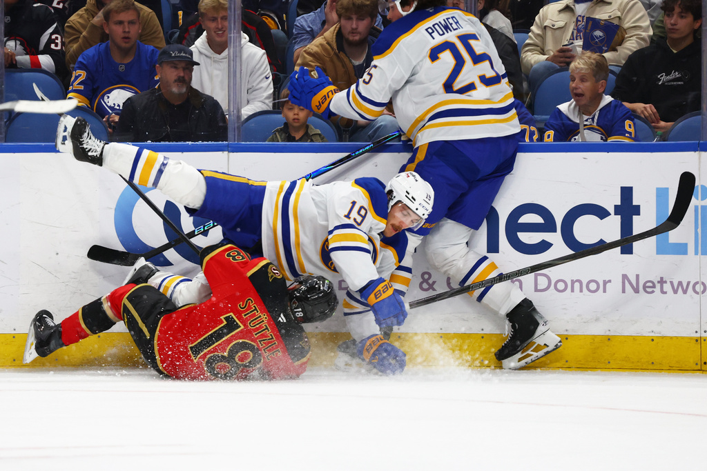 Buffalo Sabres center Peyton Krebs (19) and Ottawa Senators center Tim Stützle (18) collide along the boards during the second period of an NHL hockey game Wednesday, Oct. 15, 2025, in Buffalo, N.Y. (AP Photo/Jeffrey T. Barnes)