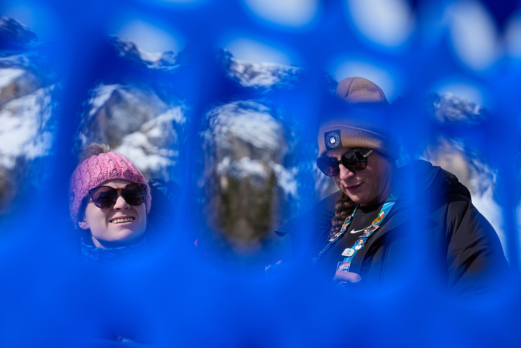 CORRECTS TO IHEART FROM ESPN - iHeart's Sarah Spain and her producer, Alex Azzi, wait to interview the athletes after the first run of an alpine ski women's giant slalom race at the 2026 Winter Olympics in Cortina d'Ampezzo, Italy, Sunday, Feb. 15, 2026. (AP Photo/Andy Wong)