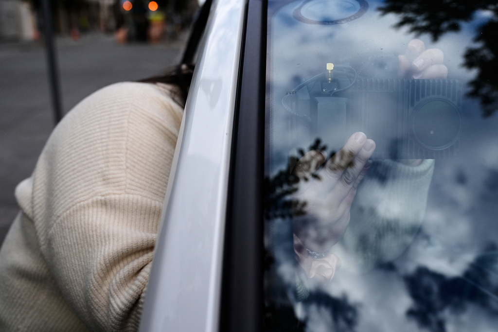 Chelsea Palacio, public information manager for the City of San Jose, adjusts a small detection camera – which uses AI to detect road hazards and potholes – mounted inside one of the city's parking enforcement vehicles, in San Jose, Calif., Wednesday, Nov. 12, 2025. (AP Photo/Godofredo A. Vásquez)