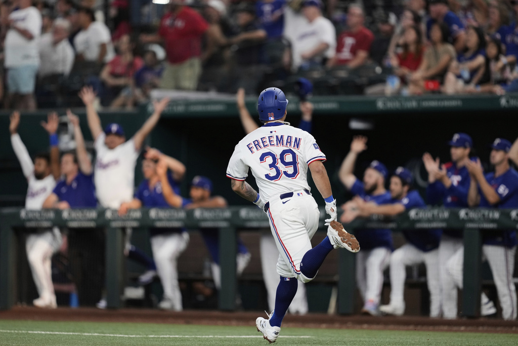Texas Rangers' Cody Freeman celebrates as he sprints past the dugout after hitting a two-run home run in the second inning of a baseball game against the Cleveland Guardians Saturday, Aug. 23, 2025, in Arlington, Texas. (AP Photo/Tony Gutierrez)