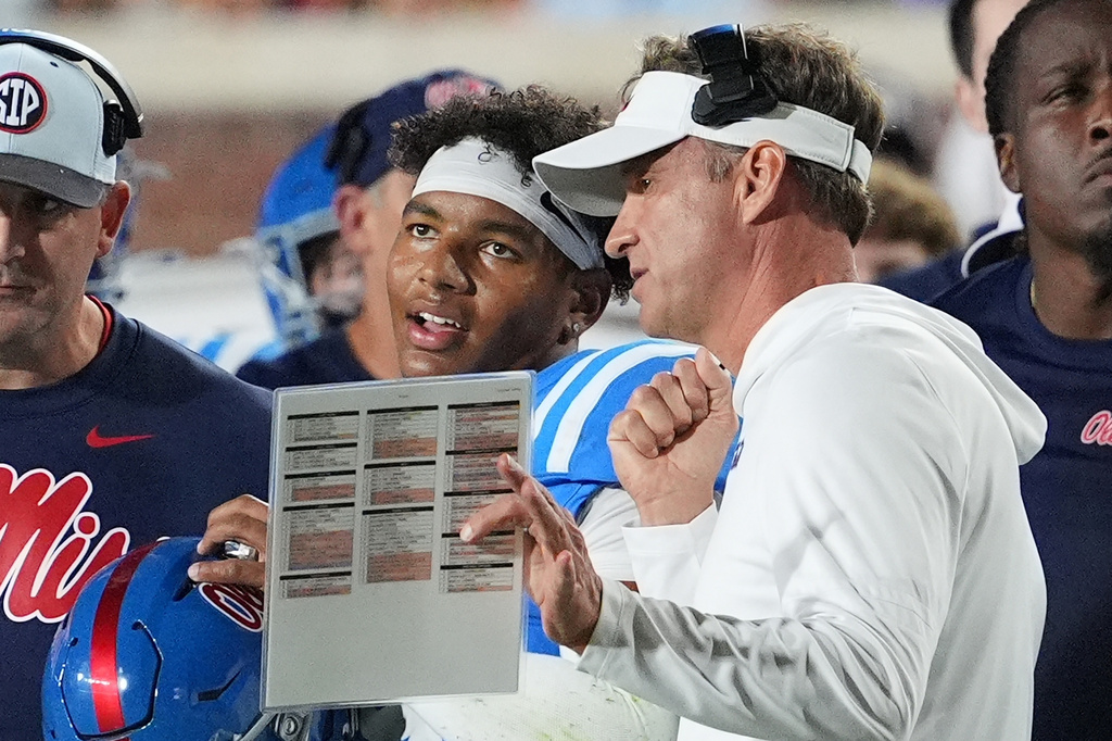 FILE - Mississippi head coach Lane Kiffin, center right, confers with quarterback Trinidad Chambliss, center left, during an NCAA college football game against Florida, Nov. 15, 2025, in Oxford, Miss. (AP Photo/Rogelio V. Solis, File)
