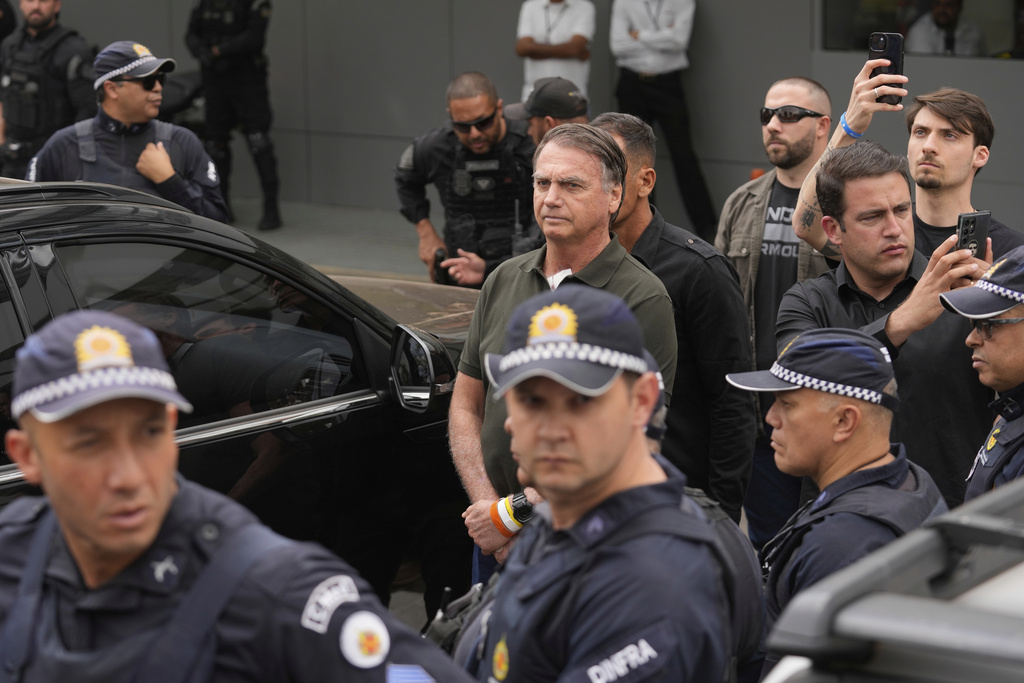 Former President Jair Bolsonaro, center, temporarily allowed out of house arrest for medical treatment, departs a hospital in Brasilia, Brazil, Sunday, Sep. 14, 2025. (AP Photo/Eraldo Peres)