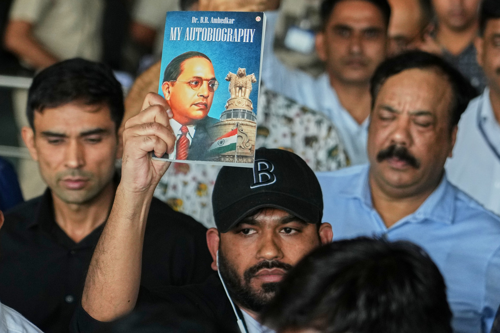 Abhijeet Dipke, center, founder of Cockroach Janta Party shows the autobiography of Bhim Rao Ambedkar as he comes out at Indira Gandhi International airport in New Delhi, India, Saturday, June 6, 2026. (AP Photo/Manish Swarup)