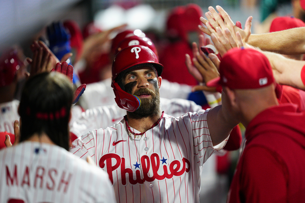 Philadelphia Phillies' Bryce Harper celebrates in the dugout after hitting a three-run home run off St. Louis Cardinals pitcher Ryan Fernandez during the sixth inning of a baseball game, Saturday, Aug. 22, 2026, in Philadelphia. (AP Photo/Derik Hamilton)