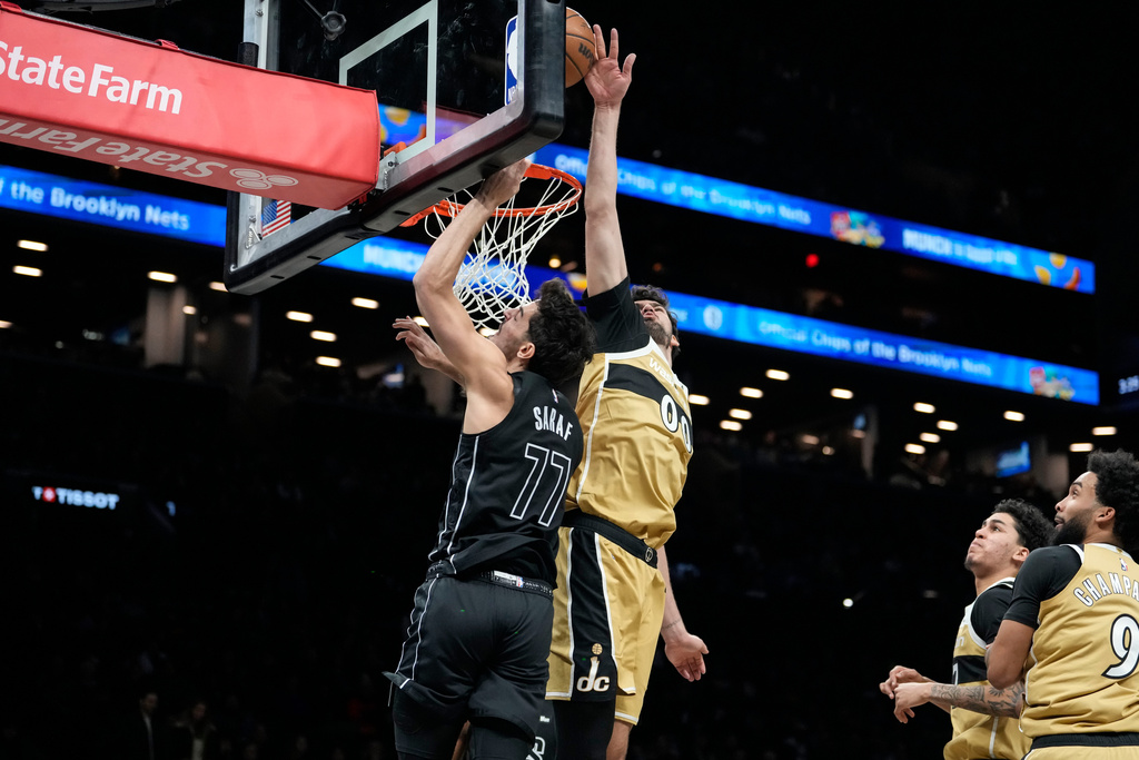 Brooklyn Nets guard Ben Saraf (77) is blocked by Washington Wizards forward Tristan Vukcevic (00) during the first half of an NBA basketball game, Saturday, Feb. 7, 2026, in New York. (AP Photo/Yuki Iwamura)