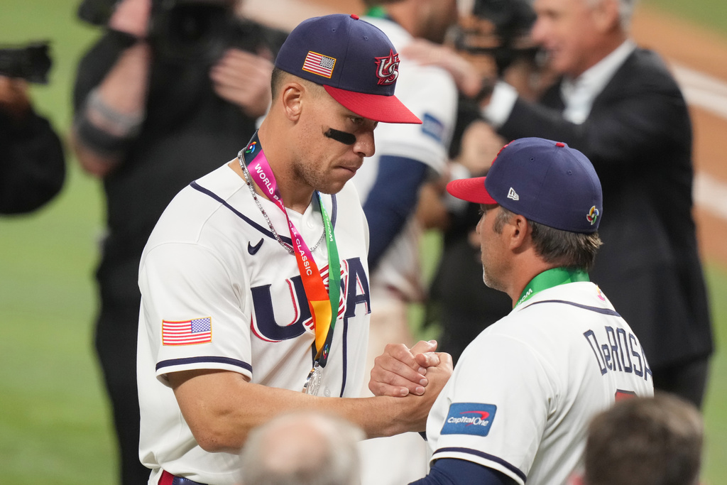 United States right fielder Aaron Judge shakes hands with manager Mark DeRosa after receiving their silver medals following the championship game of the World Baseball Classic against Venezuela, Tuesday, March 17, 2026, in Miami. (AP Photo/Lynne Sladky)