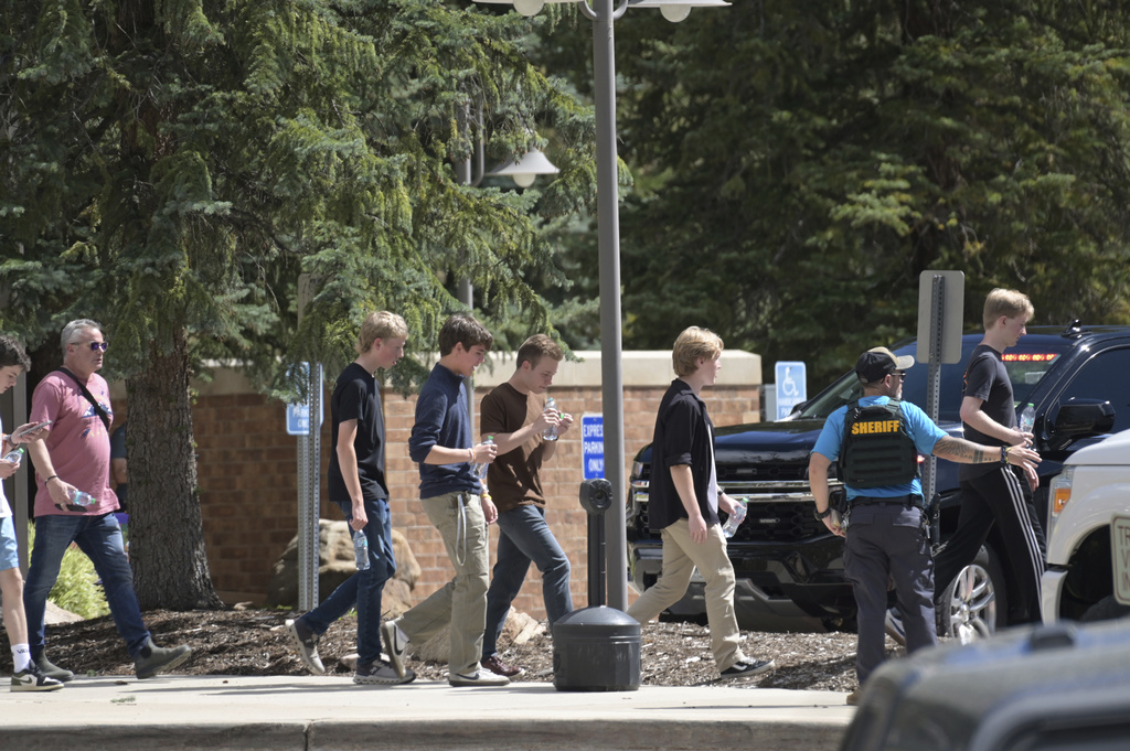 Students walk to board a bus amid heavy police presence at the Evergreen Library after a shooting at Evergreen High School in Evergreen, Colo., on Wednesday, Sept. 10, 2025. (Hyoung Chang/The Denver Post via AP)