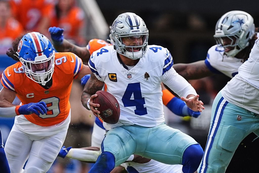 Dallas Cowboys quarterback Dak Prescott (4) scrambles in the pocket under pressure from Denver Broncos safety Talanoa Hufanga (9) in the second half of an NFL football game Sunday, Oct. 26, 2025, in Denver. (AP Photo/David Zalubowski)