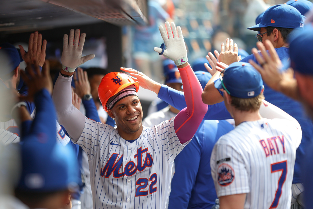 New York Mets' Juan Soto (22) celebrates in the dugout after his grand slam during the sixth inning of a baseball game against the Miami Marlins, Sunday, May 31, 2026, in New York. (AP Photo/Heather Khalifa)