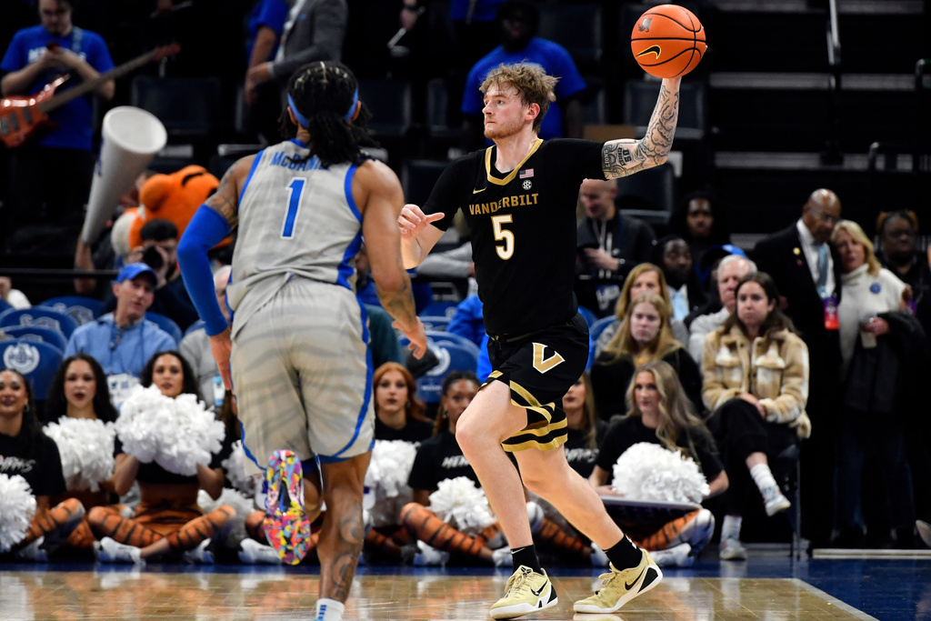 Vanderbilt forward Tyler Nickel (5) handles the ball ahead of Memphis guard Dug McDaniel (1) in the first half of an NCAA college basketball game Wednesday, Dec. 17, 2025, in Memphis, Tenn. (AP Photo/Brandon Dill)