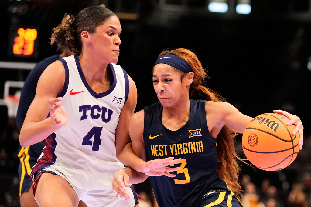 West Virginia guard Gia Cooke (3) drives past TCU guard Donovyn Hunter (4) during first half of the NCAA college basketball championship game at the Big 12 Conference tournament Sunday, March 8, 2026, in Kansas City, Mo. (AP Photo/Charlie Riedel)