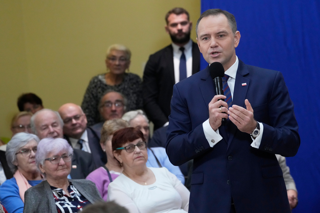Polish President Karol Nawrocki meets senior citizens and signs a draft law to their benefit during a visit to the public library in Sochaczew, near Warsaw, Poland, Monday, Nov. 3, 2025. (AP Photo/Czarek Sokolowski)