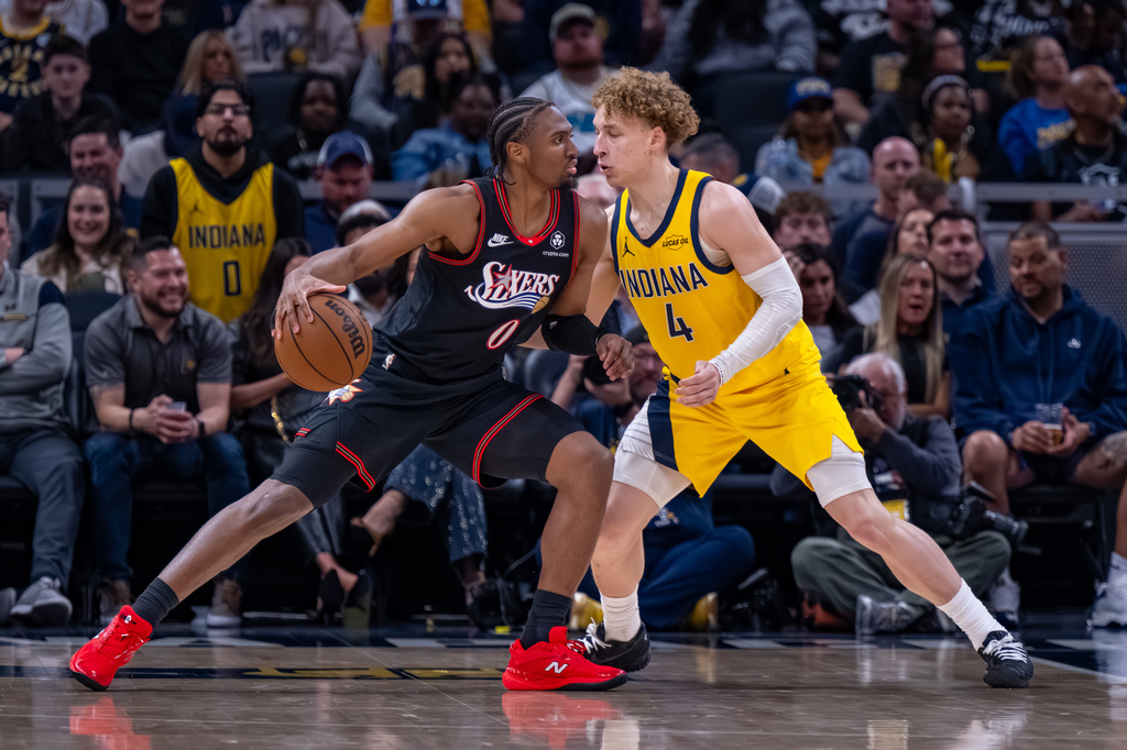 Philadelphia 76ers guard Tyrese Maxey (0) works the ball against the defense of Indiana Pacers guard Taelon Peter (4) during the second half of an NBA basketball game in Indianapolis, Friday, April 10, 2026. (AP Photo/Doug McSchooler)