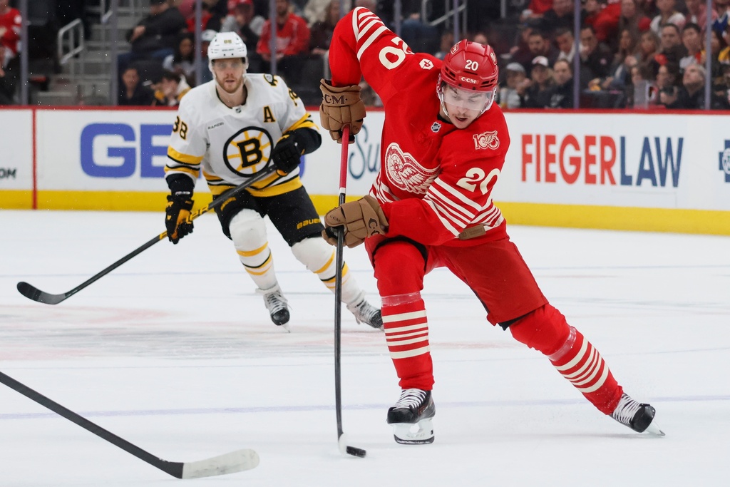Detroit Red Wings defenseman Albert Johansson (20) is pursued by Boston Bruins right wing David Pastrnak (88) while skating toward the goal during the first period of an NHL hockey game Saturday, March 21, 2026, in Detroit. (AP Photo/Duane Burleson)