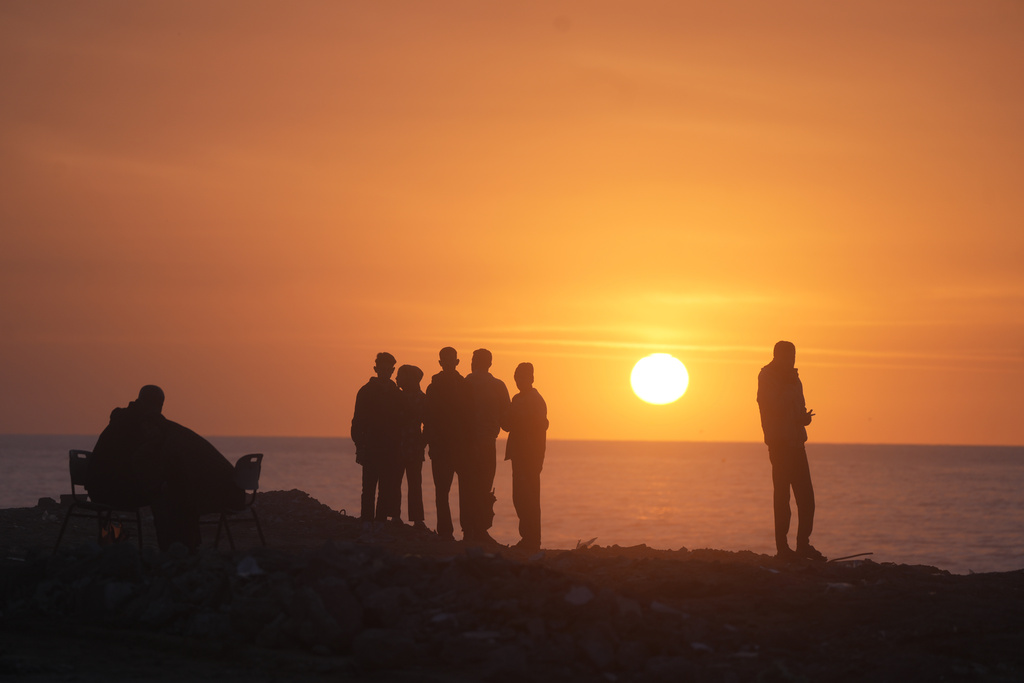 Palestinians watch the sun set over the Mediterranean Sea in Gaza City, Thursday, Jan. 29, 2026. (AP Photo/Jehad Alshrafi)