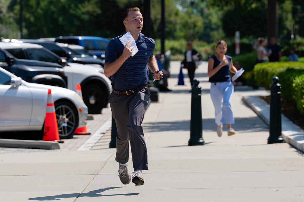 Interns run to deliver documents to the media after a Supreme Court ruling outside the Supreme Court on Capitol Hill, Tuesday, June 30, 2026, in Washington. (AP Photo/Jose Luis Magana)