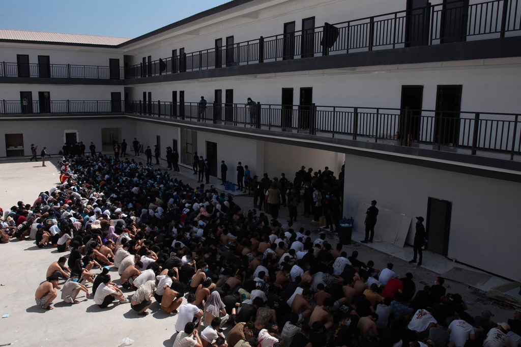 FILE - People from China, Vietnam and Ethiopia, believed to have been trafficked and forced to work in scam centers, sit with their faces masked while in detention after being released from the centers in Myawaddy district in eastern Myanmar, Wednesday, Feb. 26, 2025. (AP Photo/Thanaphon Wuttison, File)