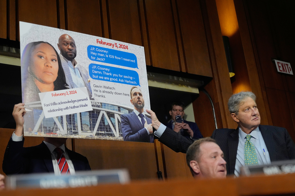 Sen. Eric Schmitt, R-Mo, seated right, with Sen. John Kennedy, R-La., standing right, during a discussion about text messages with former special counsel Jack Smith, as Smith testifies before the Senate Judiciary Committee on Capitol Hill, in Washington, Tuesday, Sept. 29, 2026, as they probe his investigation of President Trump. (AP Photo/Manuel Balce Ceneta)