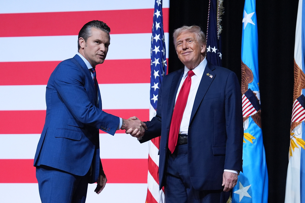 President Donald Trump is greeted by Secretary of Defense Pete Hegseth before speaking to a gathering of top U.S. military commanders at Marine Corps Base Quantico, Tuesday, Sept. 30, 2025, in Quantico, Va. (AP Photo/Evan Vucci)