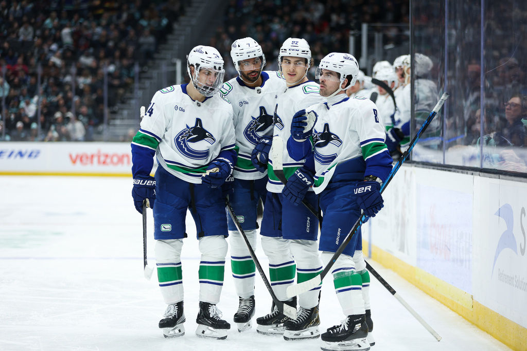Vancouver Canucks defenseman Zeev Buium (24), defenseman Pierre-Olivier Joseph (7), left wing Liam Ohgren (92) and right wing Conor Garland (8), left to right, celebrate a goal scored by left wing Liam Ohgren (92) in the second period against the Seattle Kraken during an NHL hockey game Saturday, Feb. 28, 2026, in Seattle. (AP Photo/Kevin Ng)