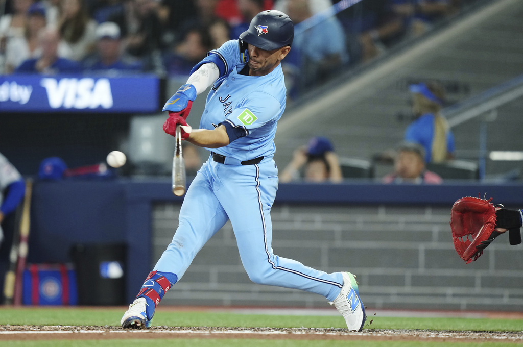Toronto Blue Jays second base Andres Gimenez (0) hits a single against the Chicago Cubs during sixth inning MLB baseball action in Toronto on Wednesday, August 13, 2025. (Nathan Denette/The Canadian Press via AP)