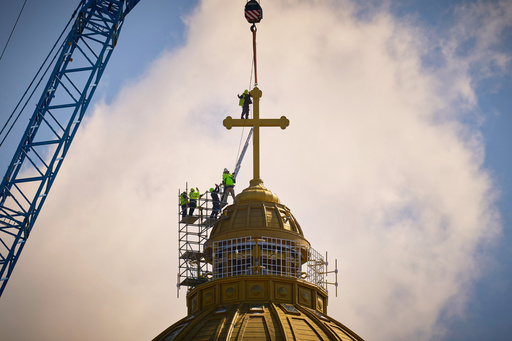 FILE - A construction worker gives a thumbs up in the final stages of installation for the main cross of the National Cathedral, in Bucharest, Romania, Tuesday, April 8, 2025. (AP Photo/Vadim Ghirda, File) FILE - A construction worker gives a thumbs up in the final stages of installation for the main cross of the National Cathedral, in Bucharest, Romania, Tuesday, April 8, 2025. (AP Photo/Vadim Ghirda, File)