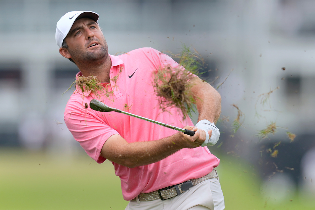 Scottie Scheffler takes a divot as he hits from the rough on the first hole during the first round of the Tour Championship golf tournament, Thursday, Aug. 27, 2026, in Atlanta. (AP Photo/Mike Stewart)