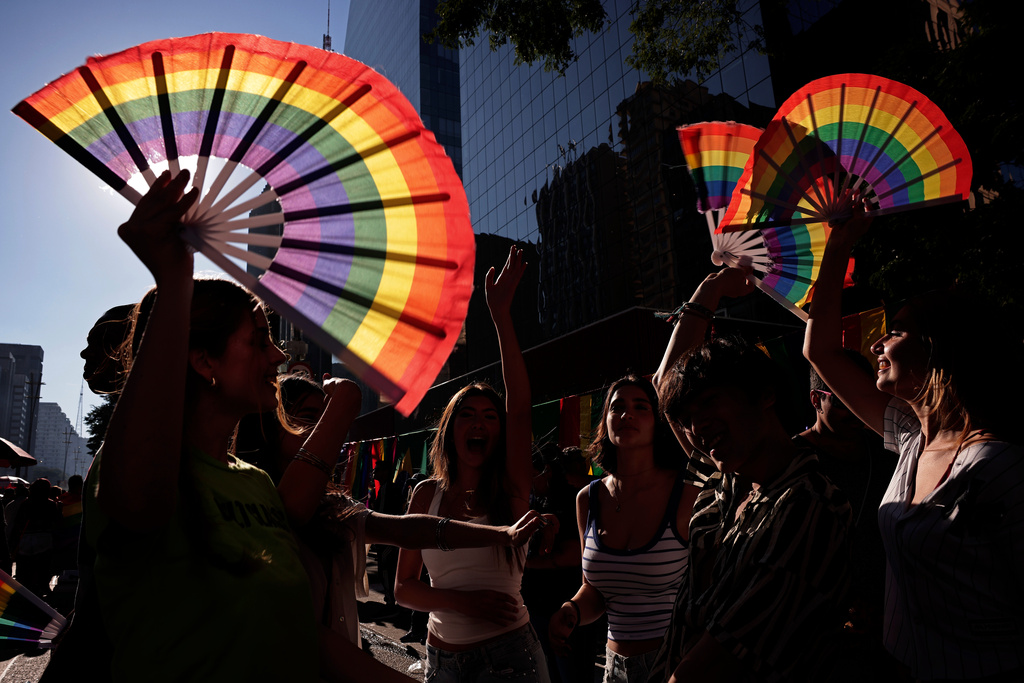 Revelers wave rainbow fans during the annual Pride Parade in Sao Paulo, Brazil, Sunday, June 7, 2026. (AP Photo/Ettore Chiereguini)