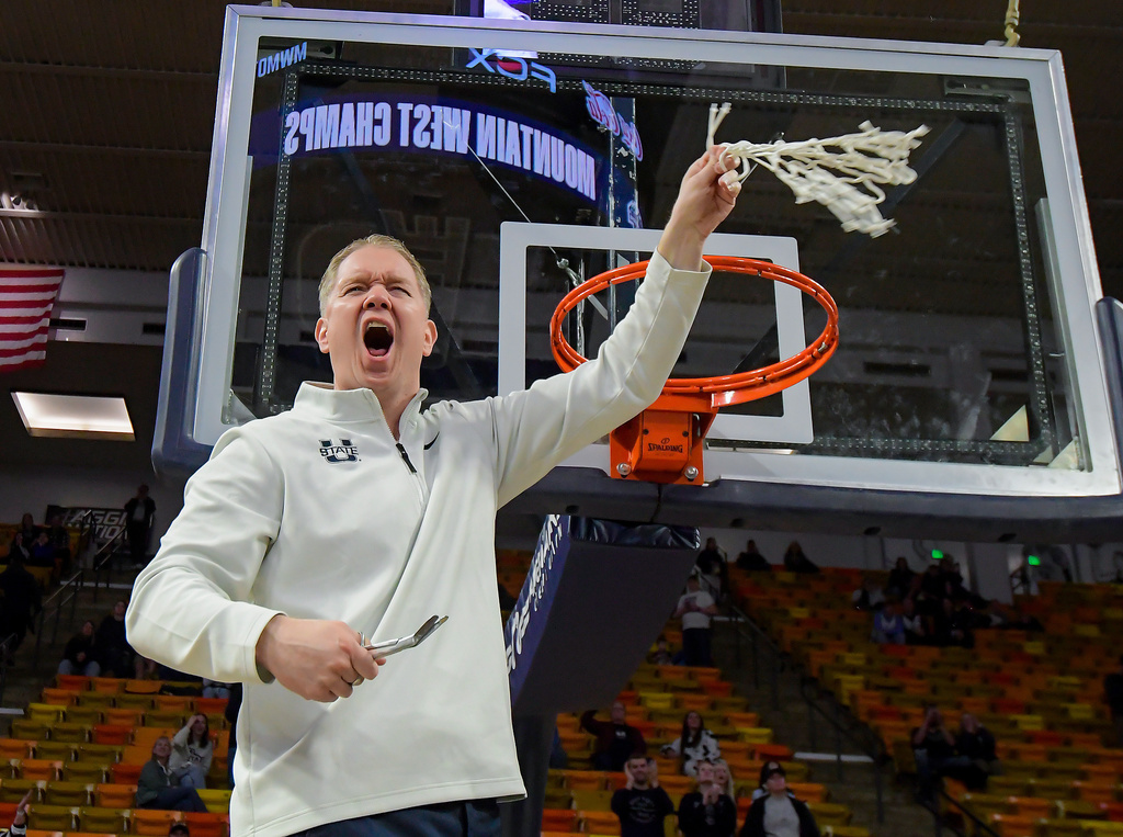 Utah State head coach Jerrod Calhoun celebrates after cutting down the net following an NCAA college basketball game against New Mexico, Saturday, March 7, 2026, in Logan, Utah. (Eli Lucero/The Herald Journal via AP)