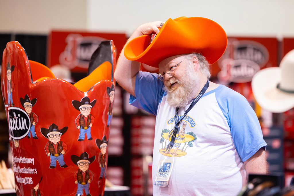 Shareholder Alex Vacca of Milwaukee poses for a photo in a foam hat in the Justin display at the Berkshire Hathaway annual meeting on Saturday, May 2, 2026, in Omaha, Neb. (AP Photo/Rebecca S. Gratz)