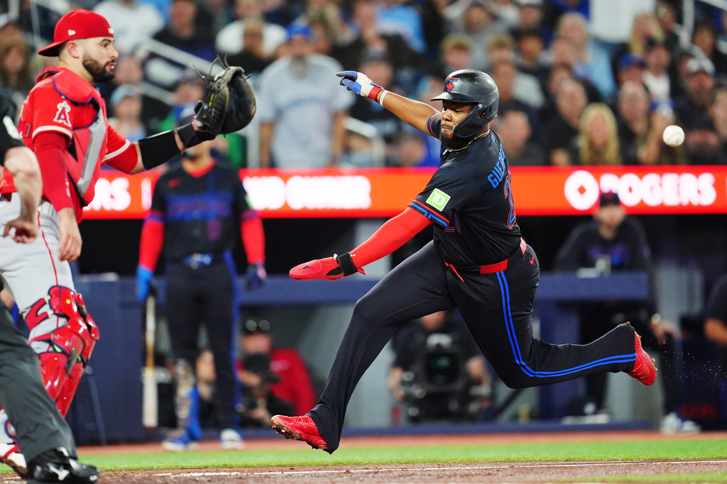 Toronto Blue Jays' Vladimir Guerrero Jr., right, runs to score head of a tag by Los Angeles Angels catcher Sebastian Rivero, left, during third-inning baseball game action in Toronto, Friday, May 8, 2026. (Frank Gunn/The Canadian Press via AP)