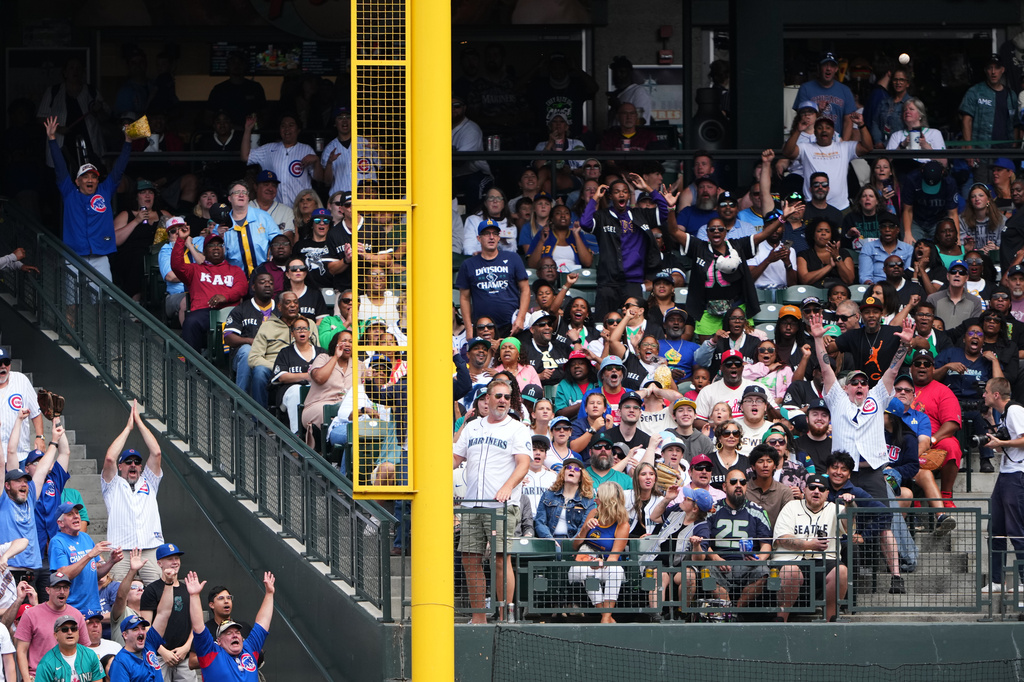 Fans react as the grand slam from Chicago Cubs' Ian Happ against the Seattle Mariners goes into the stands during the third inning of a baseball game, Sunday, Aug. 23, 2026, in Seattle. (AP Photo/Lindsey Wasson)