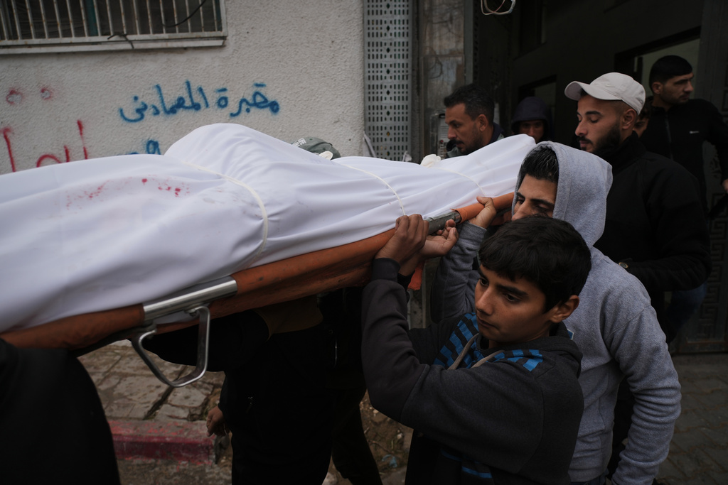 Mourners carry the body of Ibrahim Subh who was killed in an Israeli army strike, at Shifa Hospital in Gaza City, Friday, Jan. 9, 2026. (AP Photo/Jehad Alshrafi)