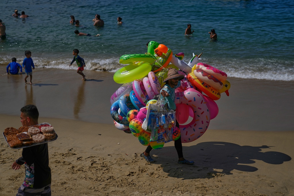 A vendor sells inflatables on Macuto beach in Venezuela, Wednesday, Dec. 17, 2025. (AP Photo/Ariana Cubillos)