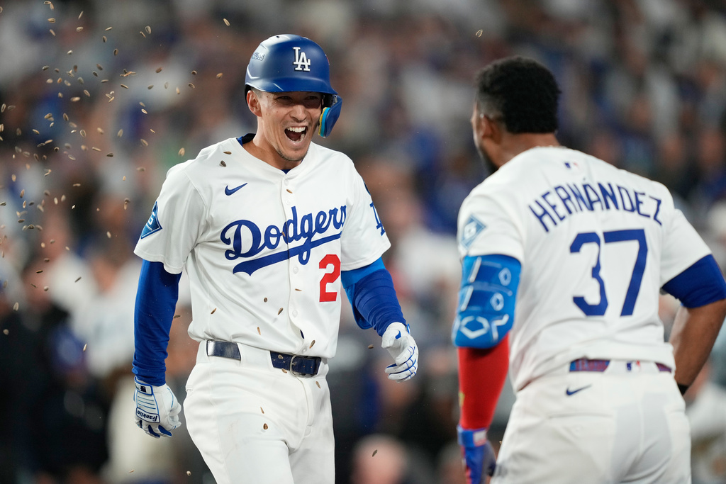 Los Angeles Dodgers' Tommy Edman, left, celebrates his solo home run with Teoscar Hernández (37) during the third inning in Game 3 of baseball's National League Division Series against the Philadelphia Phillies, Wednesday, Oct. 8, 2025, in Los Angeles. (AP Photo/Mark J. Terrill)