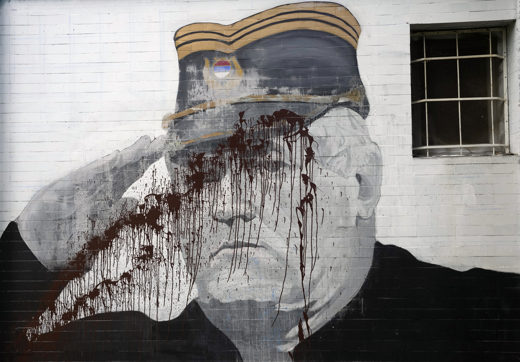 FILE - A mural of former Bosnian Serb military chief Ratko Mladic vandalized with paint in Belgrade, Serbia, Tuesday, Sept. 20, 2022. (AP Photo/Darko Vojinovic, File)
