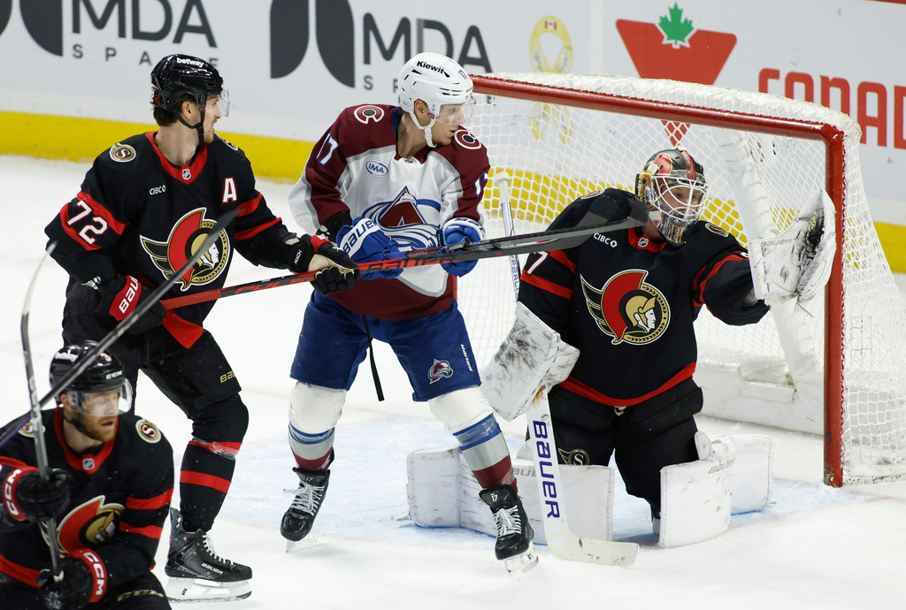 Ottawa Senators goaltender James Reimer (47) makes a save while Colorado Avalanche's Parker Kelly (17) and Senators' Thomas Chabot (72) look on during third period NHL hockey action in Ottawa on Wednesday, Jan. 28, 2026. (Patrick Doyle/The Canadian Press via AP)