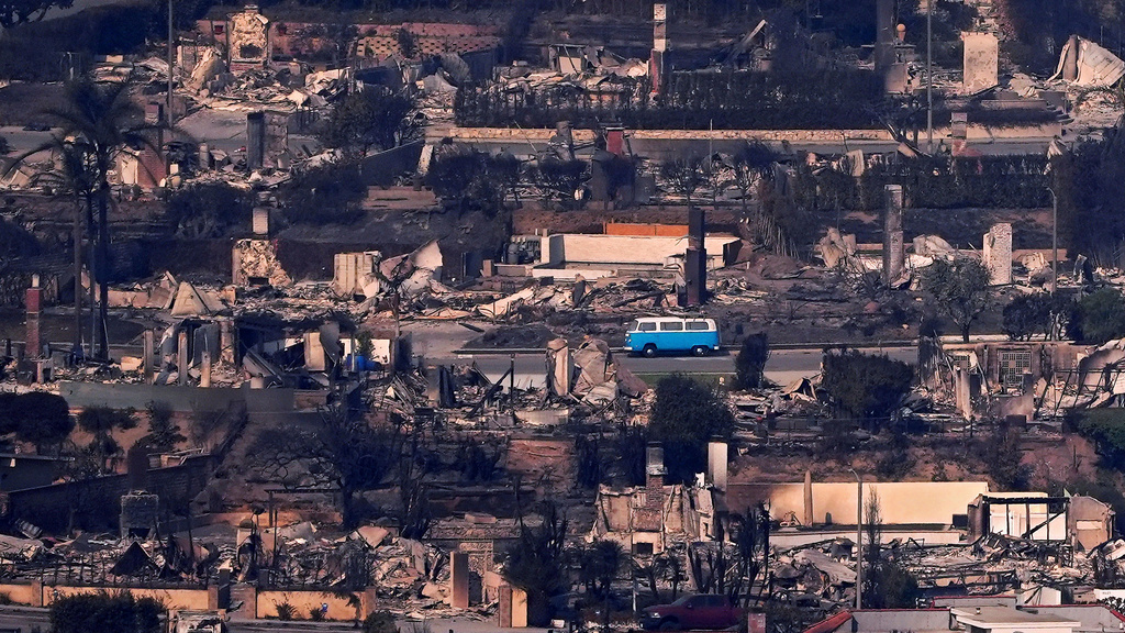 A Volkswagen bus sits among burned out homes, Jan. 9, 2025, in Malibu, Calif. (AP Photo/Mark J. Terrill, File)