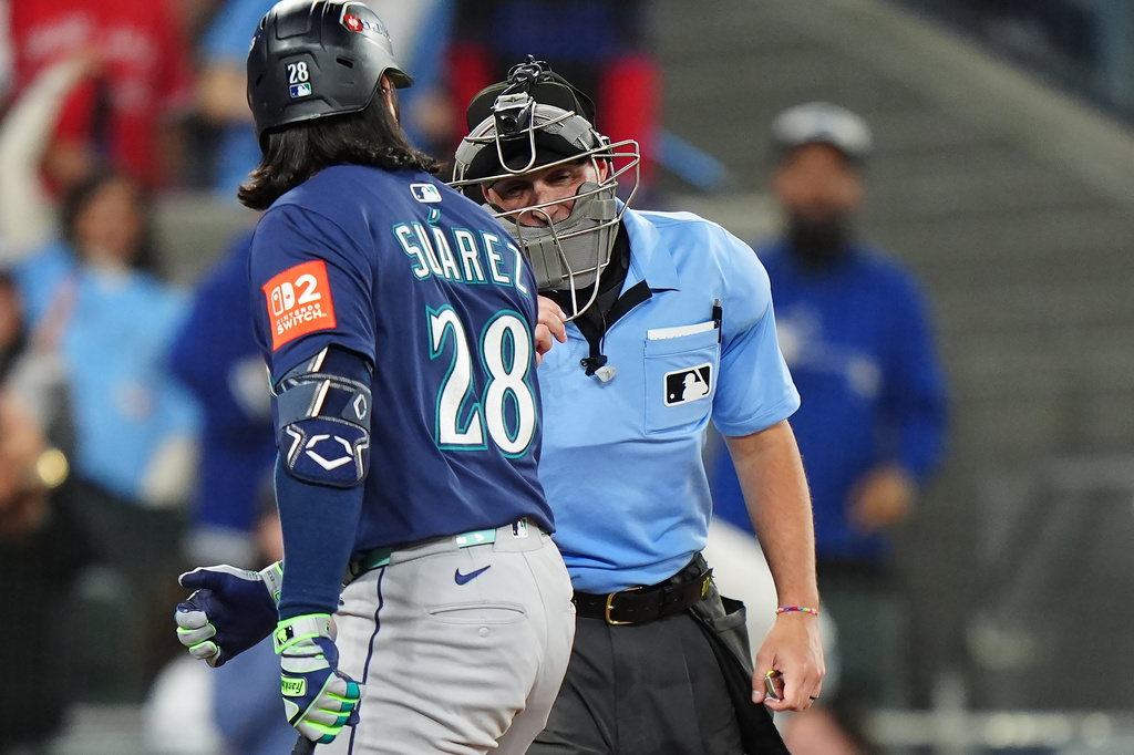 Seattle Mariners' Eugenio Suárez (28) argues with home plate umpire Quinn Wolcott, right, during the eighth inning in Game 7 of baseball's American League Championship Series against the Toronto Blue Jays in Toronto, Monday, Oct. 20, 2025. (Frank Gunn/The Canadian Press via AP)
