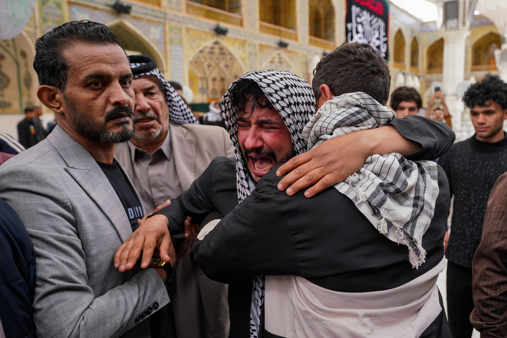 Relatives grieve an Iraqi soldier killed in a strike Wednesday on a military clinic in western Iraq's Anbar province, during a mass procession inside the shrine of Imam Ali in Najaf, Iraq, Thursday, March 26, 2026. (AP Photo/Anmar Khalil)